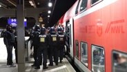 Polizeibeamte vor einem Regionalzug. © Screenshot 