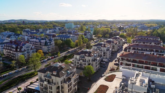 Drohnenaufnahme von städtischen Wohnhäusern in Swinemünde. Wie auf einem Reißbrett geplant, stehen sie nebeneinander, dazwischen Straßen und Grünflächen. © Screenshot 