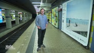 Ein Mann steht an einer U-Bahn Station vor einem dort plakatierten Foto. © Screenshot 