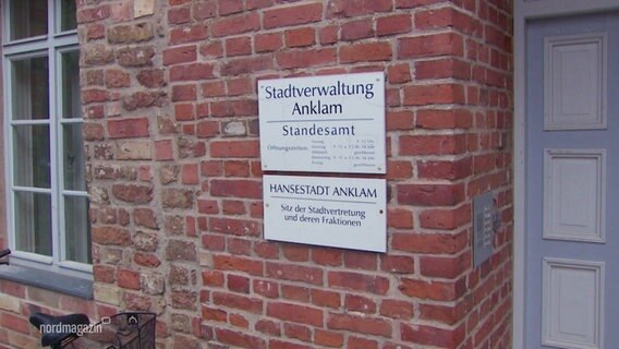 Das Eingangsschild der Stadtverwaltung Anklam ist an einer roten Steinmauer angebracht. © Screenshot 