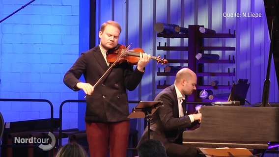 Zwei Männer geben ein klassisches Konzert. Der eine spielt Violine, der andere sitzt am Flügel. © Screenshot 