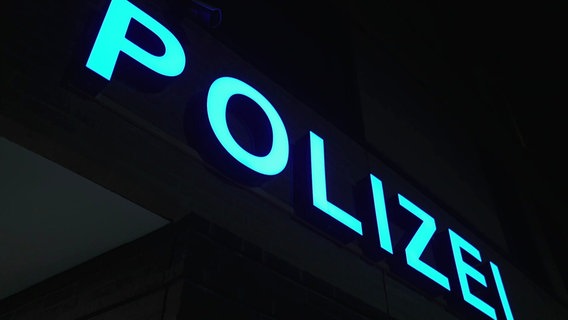 Der hellblau leuchtende Schritzug "Polizei" bei Nacht an einem Polizeigebäude in Stralsund. © Screenshot 