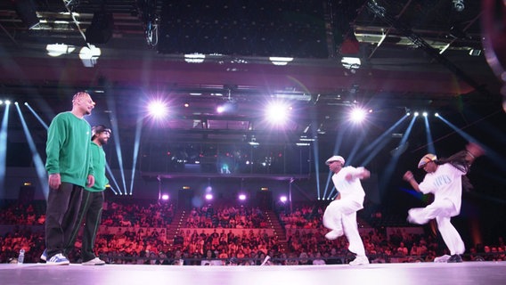Vier Street-Dancer stehen sich auf einer Bühne gegenüber, im Hintergrund Publikum auf Rängen. © Screenshot 