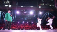 Vier Street-Dancer stehen sich auf einer Bühne gegenüber, im Hintergrund Publikum auf Rängen. © Screenshot 