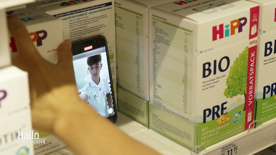 Ein Smartphone steht in einem Warenregal. © Screenshot 