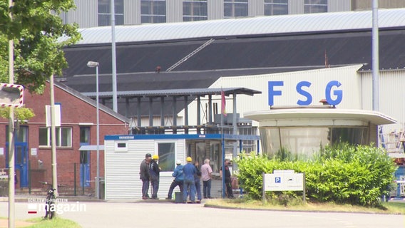 Vor dem Fördnerhaus am FSG-Gelände stehen mehrere Arbeiter. © Screenshot 