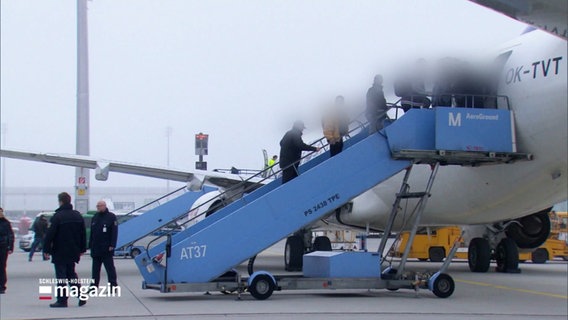 Abgeschobene Menschen besteigen ein Flugzeug. Ihre Gesichter sind unkenntlich gemacht. © Screenshot 