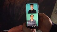 Eine Person hält ein Handy in der Hand. © Screenshot 