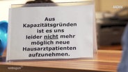 Ein Schild am Eingang einer Hausarztpraxis in Parchim © Screenshot 