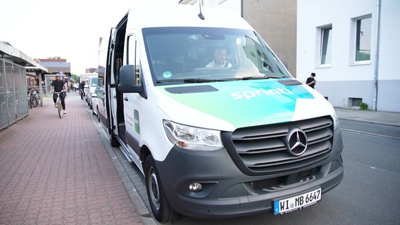 Kleinbus mit der Aufschrift "Sprinti" parkt am Straßenrand. © Screenshot 
