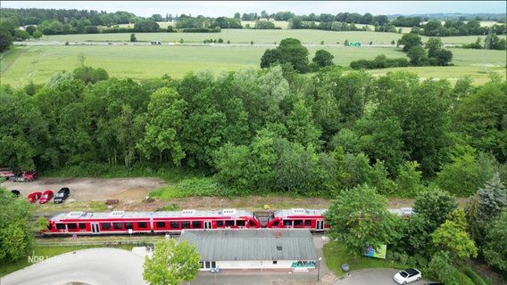 Durch einen Bahnhof fährt eine Regionalbahn. © Screenshot 