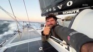 Boris Herrmann lehnt sich aus seinem Segelboot und gibt das Daumen-hoch-zeichen. © Screenshot 