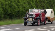 Ein Oldtimer auf einer Landstraße. © Screenshot 