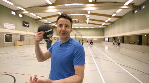 Jan Starkebaum steht in einer Sporthalle. © Screenshot 
