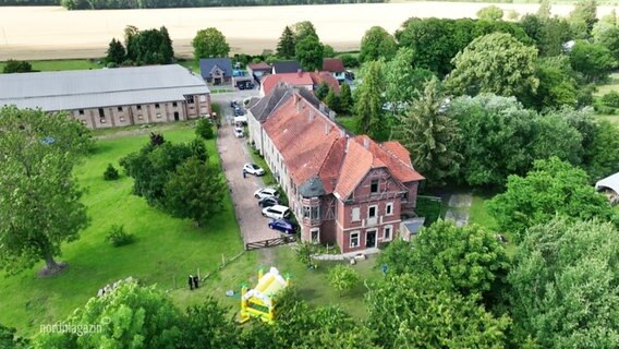Ein altes Gutshaus ist umringt von Bäumen. © Screenshot 