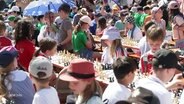 Grundschulkinder spielen auf dem Rathausmarkt Schach. © Screenshot 