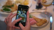 Eine Person fotografiert ihr Essen. © Screenshot 