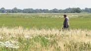 Ein Landwirt läuft auf seinem Feld. © Screenshot 