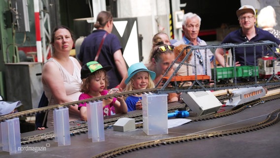Kinder stehen an einer Miniatureisenbahn. © Screenshot 