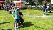 Ein Kind spielt auf dem Kinderfest mit einer Wasserspritze. © Screenshot 