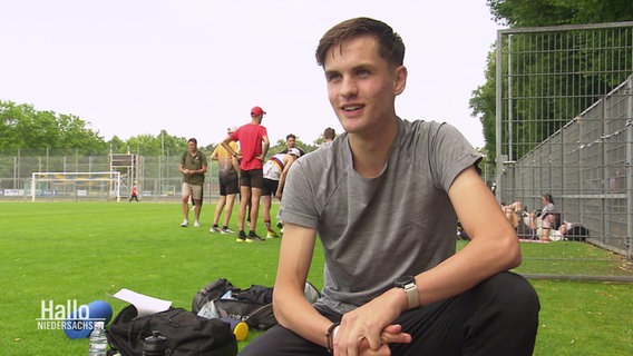 Leichtathlet Tim Kalies im Interview auf dem Sportplatz. © Screenshot 