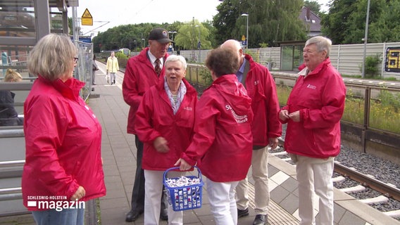 Menschen von der Bürgerinitiative „Starke Schiene“ stehen auf einem Bahnsteig. © Screenshot 
