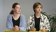 Zwei Mädchen, ein davon Mathilda Kirschnick, stehen hinter einem Pult. © Screenshot 