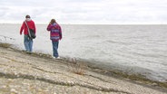Zwei Kinder laufen bei grauem Wetter am Wasser entlang. © Screenshot 