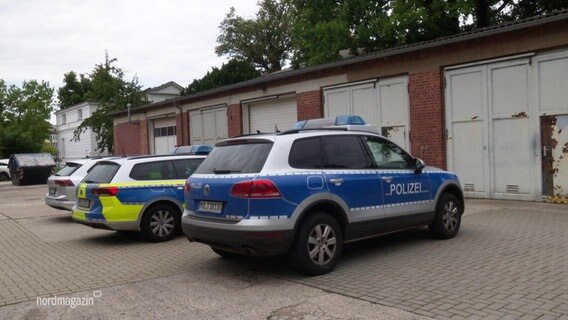 Einsatzfahrzeuge der Polizei stehen auf einem Hof. © Screenshot 