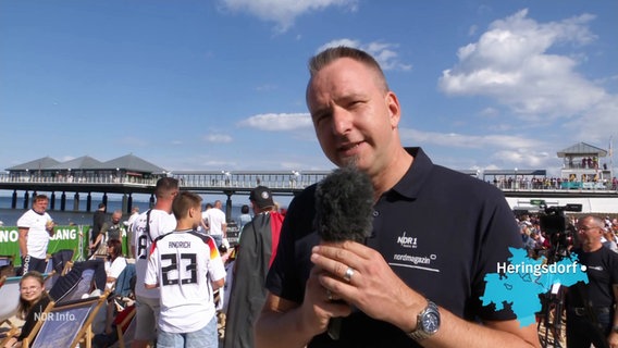 Reporter Steffen Baxalary beim Public Viewing am Strand von Heringsdorf an der Ostsee. © Screenshot 