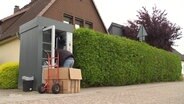 Ein Mann bestückt den Retouren-Automaten mit neuer Ware. © Screenshot 
