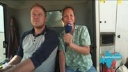 NDR-Reporterin Birgit Stamerjohanns interviewt einen Landwirt auf einem Mähdrescher. © Screenshot 