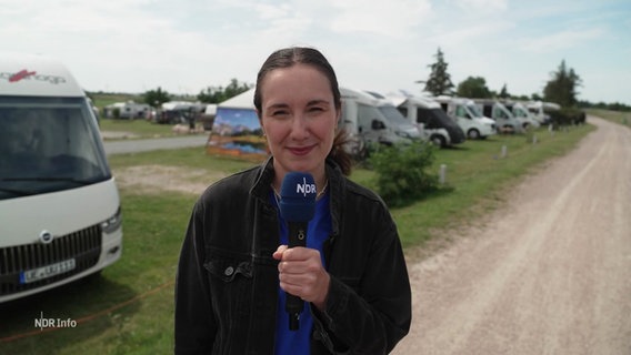NDR Reporterin Lisa Synowski steht vor einem Campingwagen. © Screenshot 