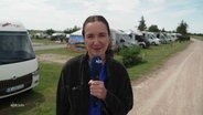 NDR Reporterin Lisa Synowski steht vor einem Campingwagen. © Screenshot 