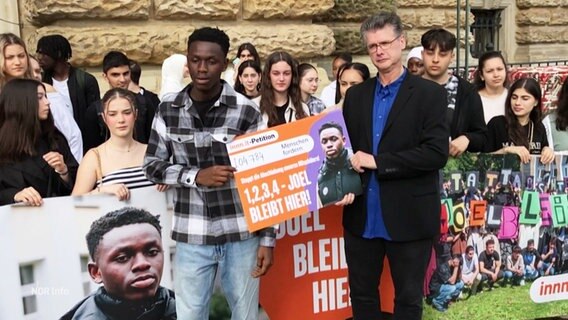 Joel und seine Mitstreiter:innen präsentieren die Petition "Joel bleibt hier" auf dem Rathausmarkt. © Screenshot 