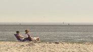 Zwei Urlauber am Strand blicken aufs Meer © Screenshot 