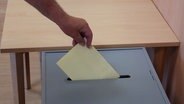 Ein Stimmzettel wird eingeworfen © Screenshot 