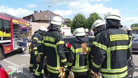 Einsatzkräfte der Feuerwehr umringen ein Auto, das gerade aufgebrochen wird. © Screenshot 