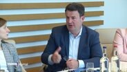 Hubertus Heil sitzt an einem Konferenztisch. © Screenshot 