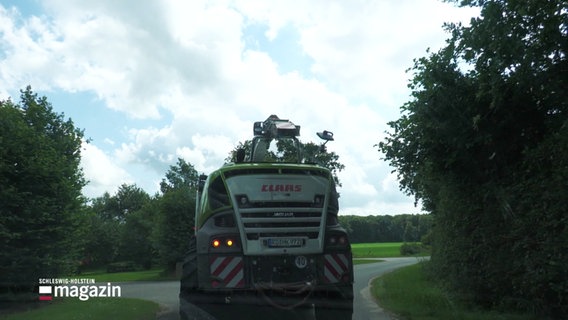 Ein Erntefahrzeug fährt eine Landstraße entlang. © Screenshot 