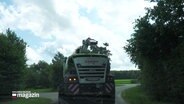 Ein Erntefahrzeug fährt eine Landstraße entlang. © Screenshot 