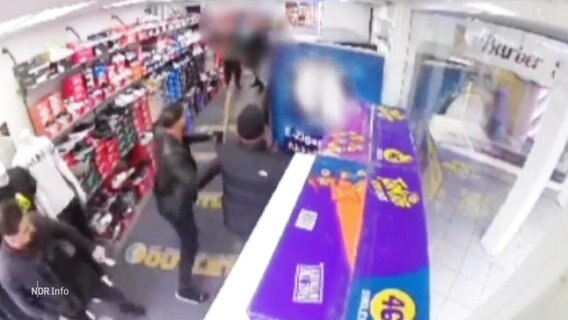 Sich prügelnde Personen auf dem Bild einer Überwachungskamera in einem Kiosk. © Screenshot 