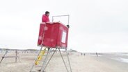 Ein Mann auf einem Aussichtsturm am Strand. © Screenshot 