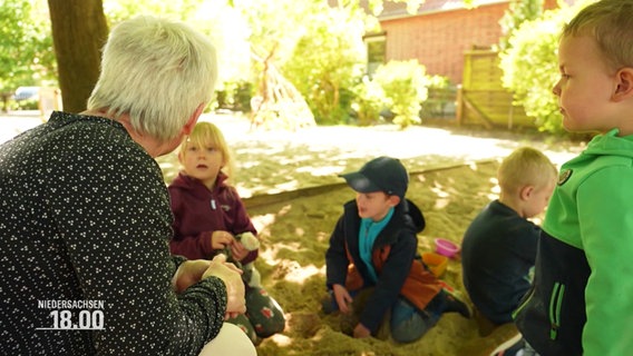 Kinder spielen in einer Sandkiste. © Screenshot 