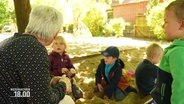 Kinder spielen in einer Sandkiste. © Screenshot 