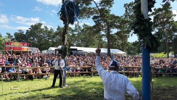 Zuschauer beobachten das traditionelle Tonnenabschlagen in Prerow. © Screenshot 