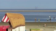 Strandszene mit Bohrinsel am Horizont. © Screenshot 