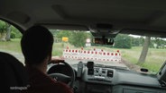 Blick aus dem Auto auf eine vollgesperrte Straße. © Screenshot 