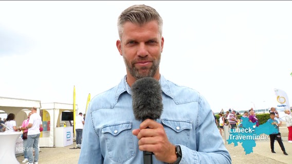 Reporter Phillip Kamke berichtet live aus Lübeck-Travemünde. © Screenshot 