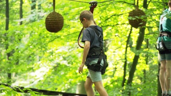 Ein junger Mensch klettert im Kletterpark. © Screenshot 